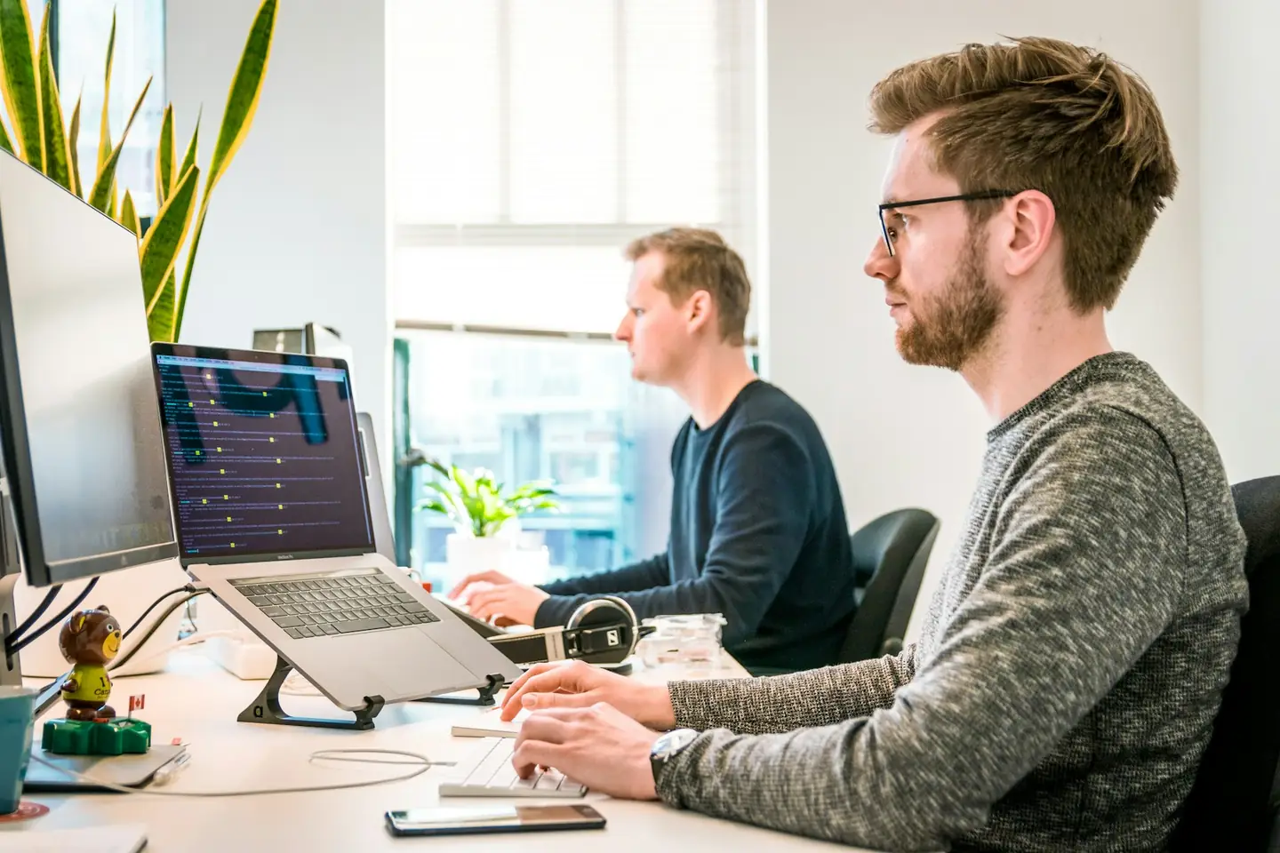 Analytics engineers working at monitors in a bright office