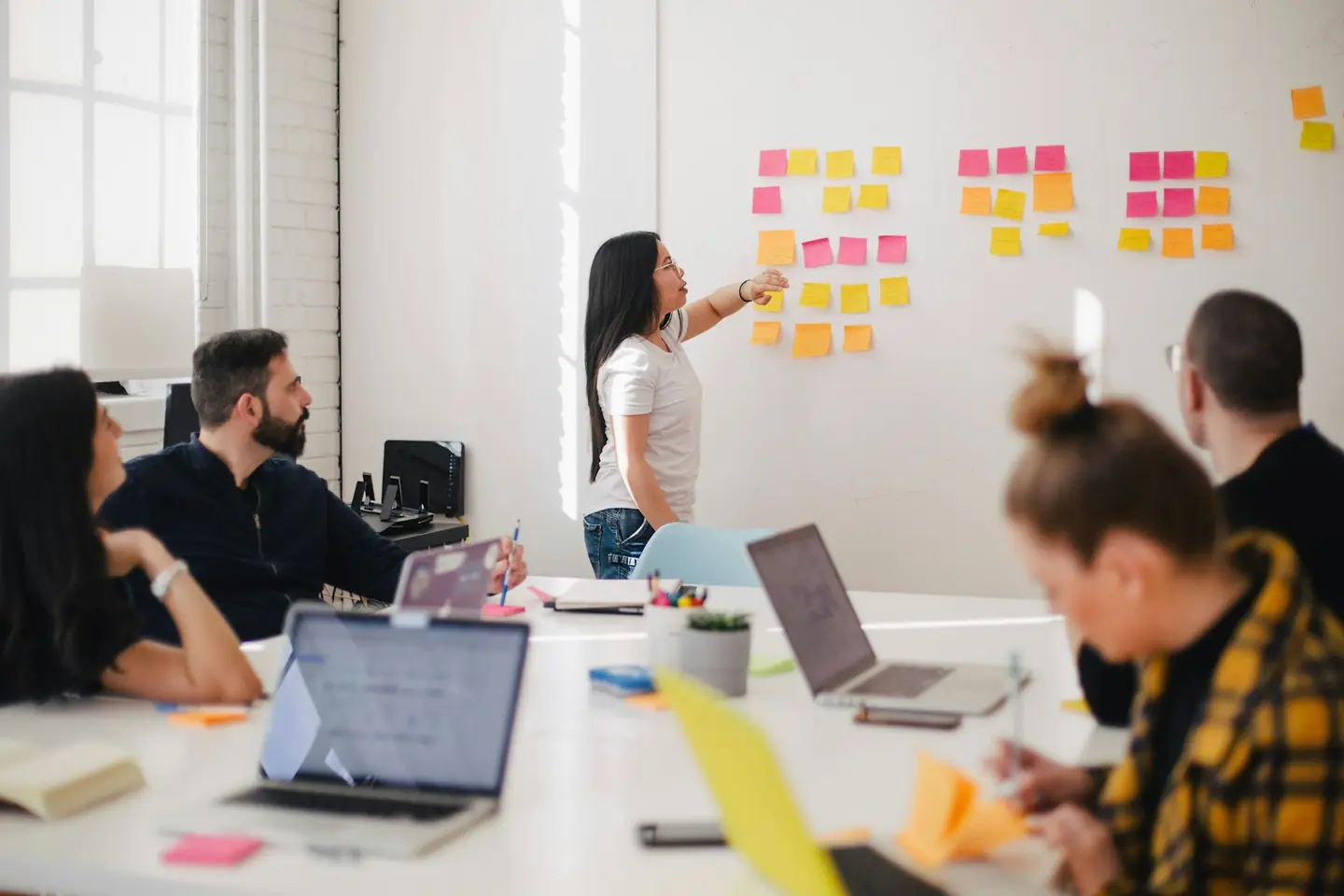 Strategy session with a team reviewing notes on a glass wall