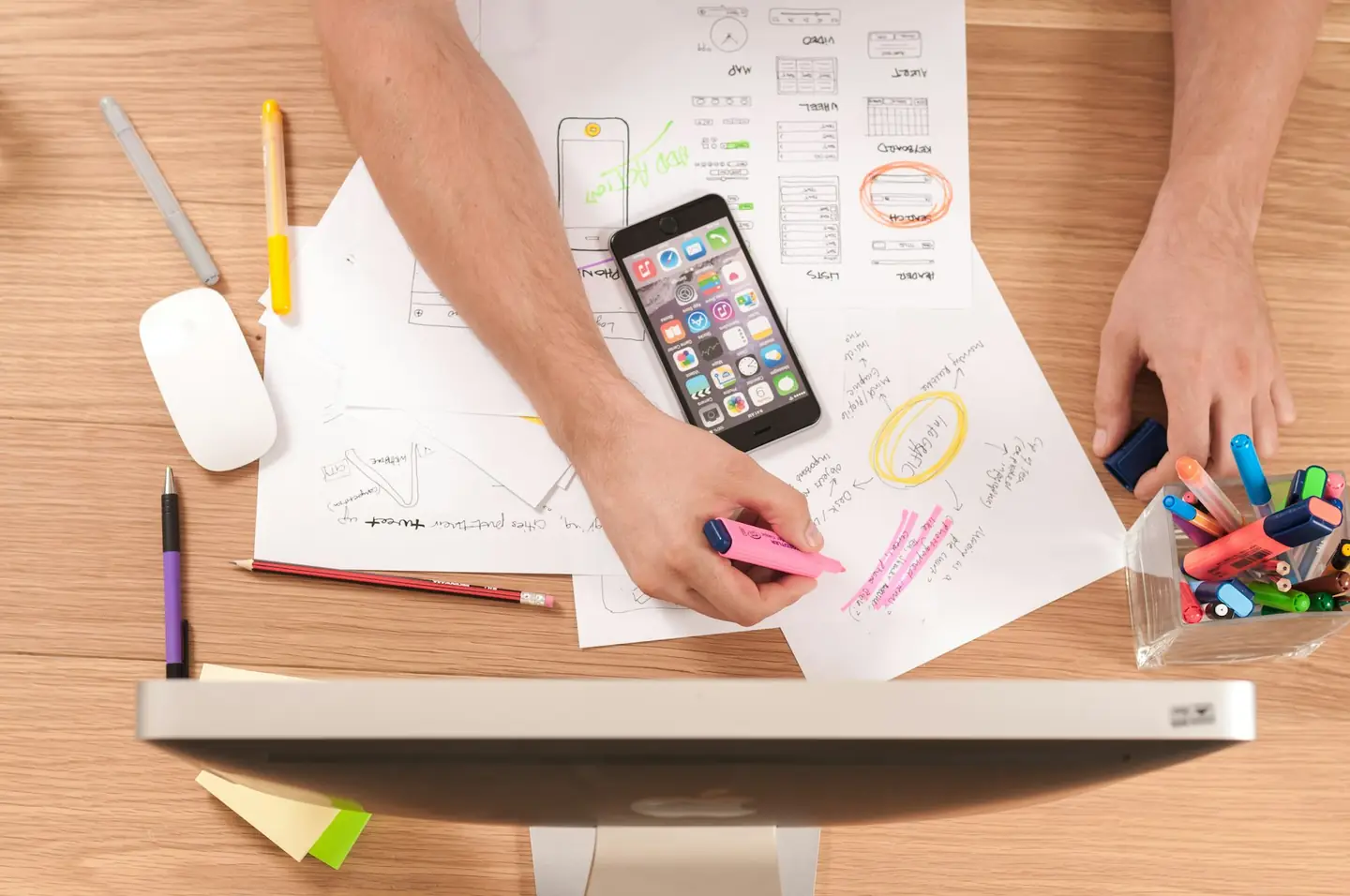 Designer sketching mobile wireframes on paper